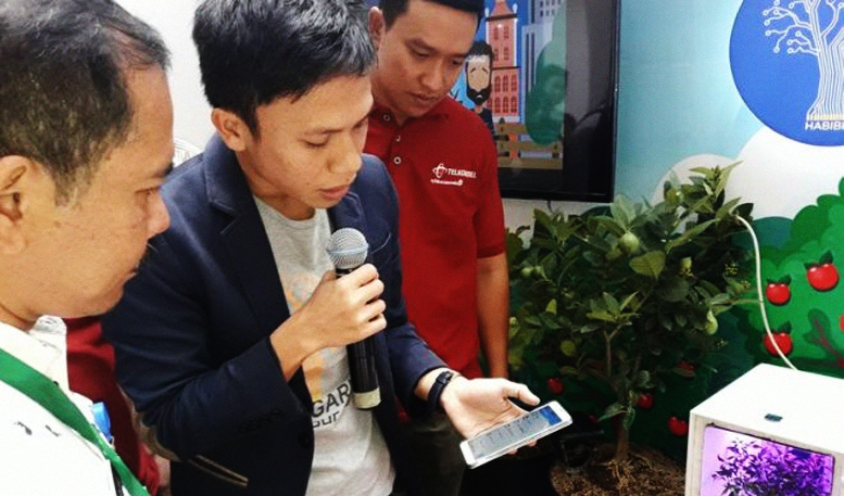 CEO Habibi Garden, Irsan Rajamin, sedang menjelaskan temuan mereka kepada Kasie Kurikulum Pembinaan dan Pengembangan, Bambang Arianto, pada acara Showcase The Nextdev Competition