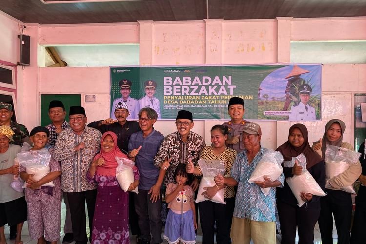 Pemerintah Desa dan Kabupaten saat berfoto bersama dengan perwakilan mustahik yang menerima zakat pertanian di Balai Desa Babadan, Kecamatan Sindang, Kabupaten Indramayu, Jawa Barat, Jumat (3/10/2025)(KOMPAS/HANDHIKA RAHMAN)